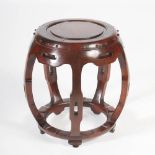 A Chinese dark wood barrel shaped stool, the panelled circular top within a simulated studded