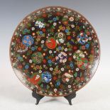 A Japanese black ground cloisonne dish, Meiji Period, decorated all over with circular shaped panels
