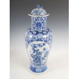 A Chinese porcelain blue and white vase and cover, Qing Dynasty, decorated with two shaped panels of