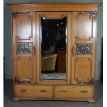 An Arts & Crafts two piece bedroom suite, comprising; mirror back dressing chest and mirror door