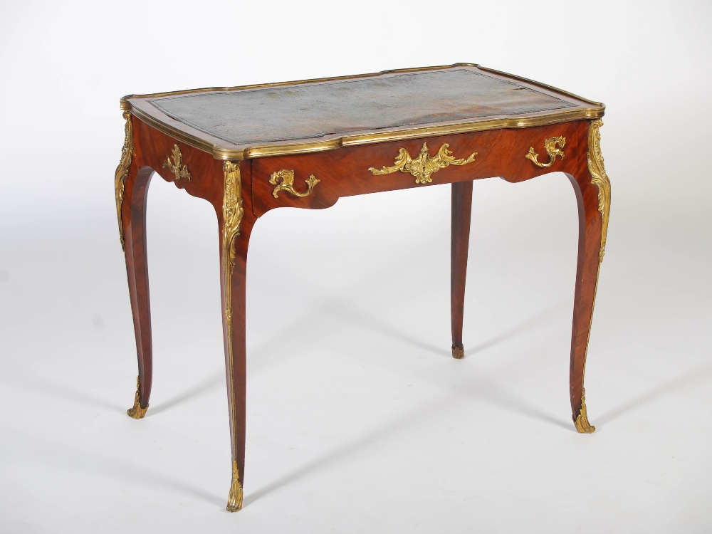 A late 19th/early 20th century mahogany and gilt metal mounted writing table in the Louis XV style