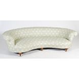 A late 19th/early 20th century walnut crescent shaped sofa by Howard & Sons, London, the curved back