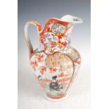 A Japanese Imari ewer, late 19th/early 20th century, decorated with panels of figures in a fenced
