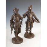 A pair of bronzed metal figures of knights, one modelled standing holding a crossbow, the other