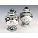 A pair of Chinese porcelain famille verte black ground jars and covers, Qing Dynasty, decorated with