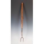 An antique pitch fork, with steel prongs and turned ash handle, 93cm long.
