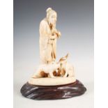 A Japanese ivory okimono of an elderly man and three monkeys, Meiji Period, on carved wood plinth,