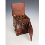 A George III mahogany table top apothecary cabinet, the hinged rectangular cover opening to a fitted