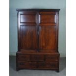 A 19th century oak hall cupboard of slender proportions, with a pair of panelled cupboard doors to