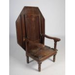 A 17th century oak monks bench, the hinged planked octagonal top with a moulded edge, above a