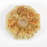 A Chinese jade octagonal shaped disc, carved to one side with precious objects, 4.8cm diameter.