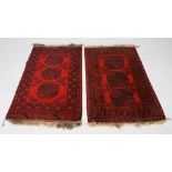 A near pair of Persian rugs, the madder grounds each decorated with three octagonal shaped guls