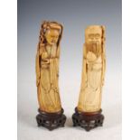 A pair of Chinese ivory figure groups carved as Guanyin and Shou Loa, Qing Dynasty, on carved and