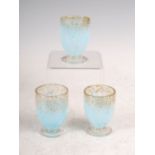 Three Monart liqueur glasses, shape QC, mottled clear and blue glass with gold coloured