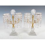 A pair of early 19th century cut glass and gilt metal mounted table lustres, the foliate and