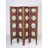 A Chinese dark wood four fold screen set with sixteen famille verte porcelain panels, late 19th/