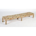 A George III style long foot stool, the rectangular top raised on six rectangular section