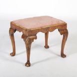 A George II style walnut stool, the rectangular upholstered drop in seat above a shaped apron,
