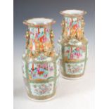 A pair of Chinese porcelain famille rose Canton vases, Qing Dynasty, decorated with panels of