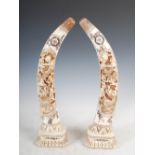 A pair of Chinese carved bone tusks, carved with oval shaped panels of dragons and cloud scrolls,