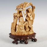 A Chinese ivory figure group, Qing Dynasty, carved with two figures under a pine tree in a rocky