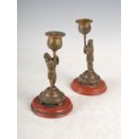 A pair of 19th century bronze chinoiserie style candlesticks, modelled with mandarin figures holding