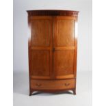 An early 20th century George III style mahogany bow front wardrobe, the moulded cornice with