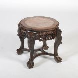 A Chinese dark wood jardiniere stand, Qing Dynasty, the shaped circular top with a mottled red