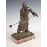 An early 20th century Continental bronze figure of a foundry worker, raised on mottled red and white
