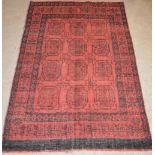 A Turkoman rug, the madder ground decorated with twelve octagonal shaped guls within multiple
