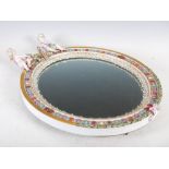 A Meissen porcelain dressing table mirror, the oval mirror plate within a foliate and cabochon