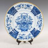 A late 18th/19th century Delft pottery charger, decorated in the Chinese style with a basket issuing
