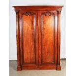 A Victorian mahogany wardrobe, the moulded cornice above a pair of panelled cupboard doors with