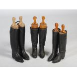 Three pairs of Vintage black leather riding boots with original wood stretchers.