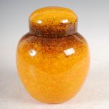 A Monart jar and cover, shape Z, mottled brown, orange and yellow glass, remains of original paper