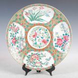 A Chinese porcelain famille rose charger, decorated with panels of peony, fruit and foliage, 33.
