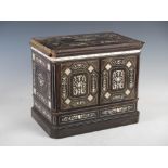 A 19th century European ebony and ivory inlaid table cabinet, the rectangular top inlaid with a