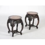 A pair of Chinese dark wood jardiniere stands, Qing Dynasty, the circular tops with mottled red