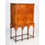 An 18th century and later walnut cabinet on stand, the rectangular top above a pair of cupboard
