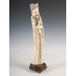 A Chinese ivory figure of a scholar, Qing Dynasty, raised on circular carved wood stand with three