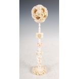 A Chinese ivory puzzle ball on stand, late Qing Dynasty, the puzzle ball carved with dragons and