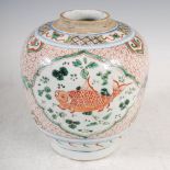 A Chinese porcelain Wucai jar, Qing Dynasty, decorated with three oval shaped panels enclosing fish,