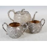 A Chinese silver three piece tea set, WANG HING, Qing Dynasty, comprising; tea pot, twin handled
