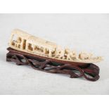 A Chinese ivory Sampan, Qing Dynasty, carved with figures rowing, on carved and pierced wood