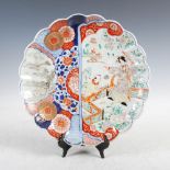 A Japanese Imari charger, late 19th/early 20th century, decorated with a shaped panel of bijin and