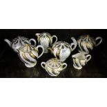 Collection of gold & cream teapots, etc