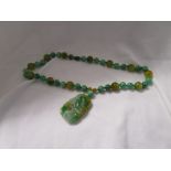 Honey & emerald green jade necklace with carved jade pendant