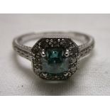 18ct White gold ring set with a square green diamond surrounded by white diamonds