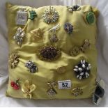 Collection of brooches on cushion (some signed)