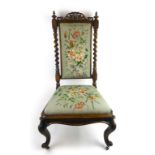 A Victorian walnut nursing chair upholstered in blue floral embroidery,